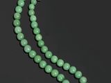un collier de perles de jade vert et une paire de boucles d'oreilles