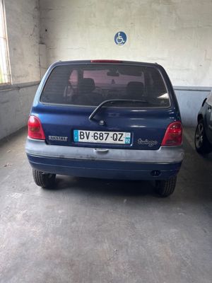 une voiture bleue garée dans un garage à côté d'une voiture noire