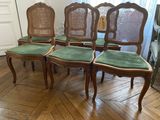 four chairs are lined up in a row on a wooden floor