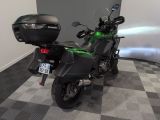 a green motorcycle parked in a room with a checkered floor