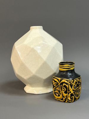 two vases sitting next to each other on a gray surface