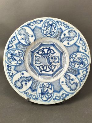 un gros plan d'une assiette bleue et blanche posée sur une table