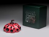 a small red ladybug sitting next to a green box