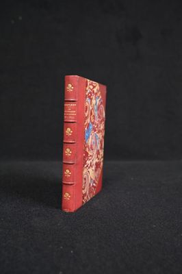 un petit livre rouge posé sur une table noire