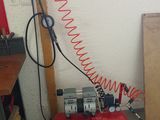 a red air compressor sitting on the floor next to a window
