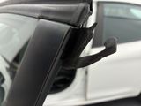 a close up of a car door handle with a car in the background