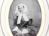 an old photo of a woman in a black and white dress