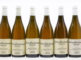 six bouteilles de vin blanc sont alignées