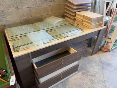 a glass top desk with a drawer underneath it