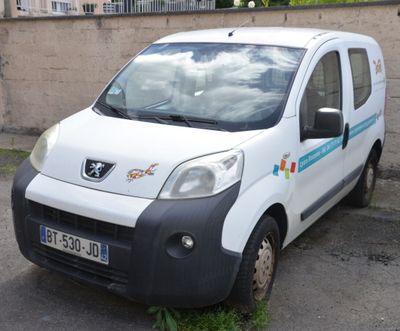 une petite camionnette blanche garée sur le bord de la route
