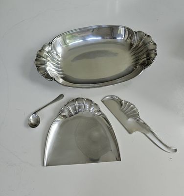 a silver plate with spoons and spoon rest on a table