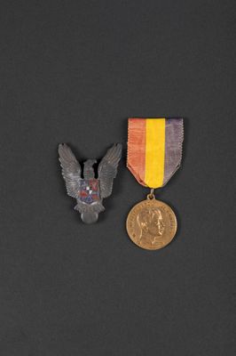 two medals and a medal on a black surface