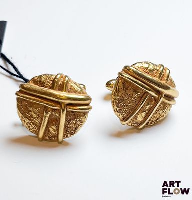 une paire de boucles d'oreilles dorées ornées d'un nœud à chaque extrémité