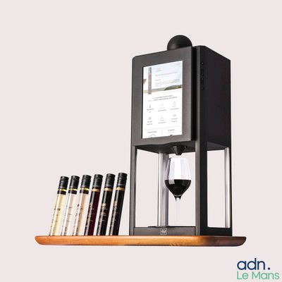 an image of a wine dispenser with a glass of wine next to it