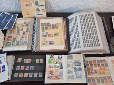beaucoup de timbres posés sur une table, à côté d'un livre