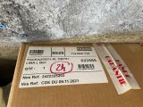 une boîte en carton avec un autocollant dessus, posée par terre