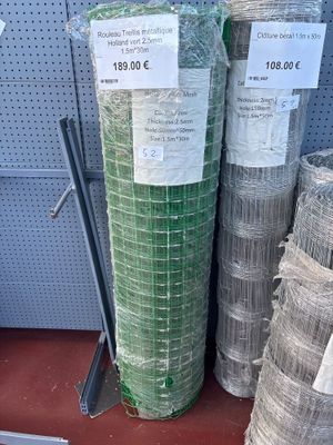 several rolls of wire mesh are stacked on a shelf in a store