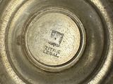 a close up of a metal bowl with a lid on a table