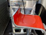 a red chair that is sitting in front of an oven