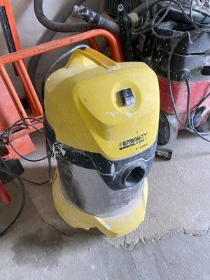 un aspirateur jaune et noir posé à côté d'une chaise rouge