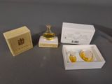 a small bottle of perfume next to a small box of perfume