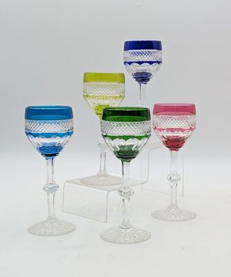 plusieurs verres à vin de différentes couleurs posés sur une table blanche