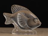 a glass figurine of a fish sitting on a table