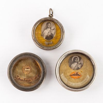 three small silver lockes with pictures of a woman and a man on them