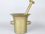 a brass mortar and a pestula on a white background