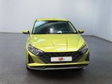 the front of a yellow car in a room with a white wall