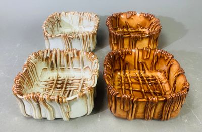 deux vases marron et blancs posés l'un à côté de l'autre sur une table
