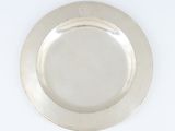 une photo d'une assiette en argent posée sur une table blanche