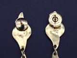 pair of silver earrings with black stones on a blue surface