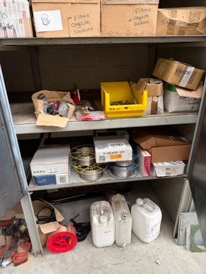 une étagère métallique sur laquelle sont posées des boîtes et d'autres objets