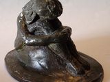 une statue représentant un chien assis sur un rocher