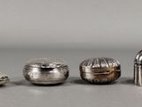 Trois objets en argent sont posés les uns à côté des autres sur une table.