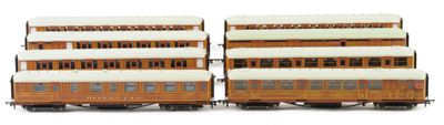 two brown and white train cars sitting side by side