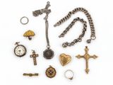 une photo d'une collection de bijoux comprenant une croix, une montre de poche, une bague et un collier