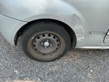 a silver car with a flat tire on the street