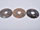 two old metal donuts sitting next to each other on a white surface