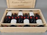 bottles of red wine in a wooden box on a table