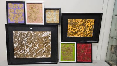 quatre tableaux encadrés, de couleurs et de motifs variés, accrochés au mur