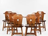six wooden chairs sitting in a row on a white surface