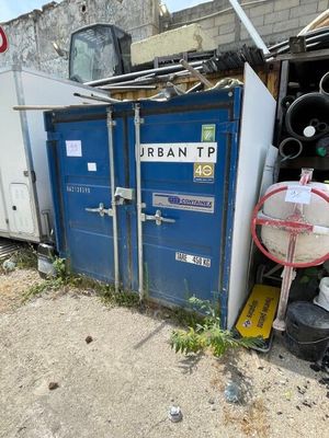 un conteneur bleu posé à l'extérieur d'un immeuble