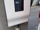 une voiture rouge garée à côté d'une borne de recharge électrique dans la rue