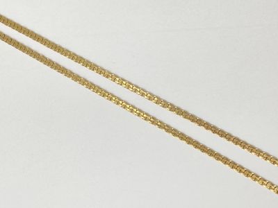 two gold chain necklaces on a white surface with a white background
