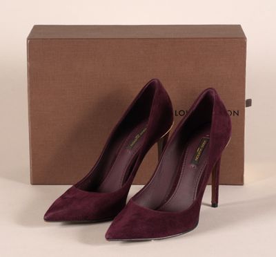 une paire d'escarpins violets posée sur une boîte