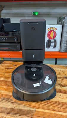 une photo d'un aspirateur robot posé sur une table en bois