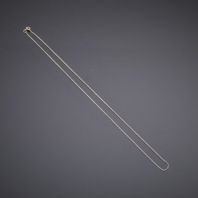 une image représentant une chaîne en argent sur fond gris