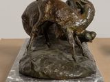 statue of a dog on a rock on a wooden table